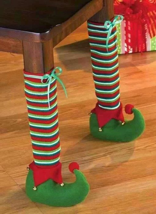 Patas de una mesa decorada con calcetines y botas de un duende 