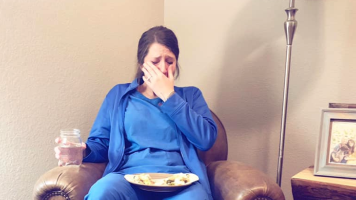 Enfermera llorando en el sofá de su casa 