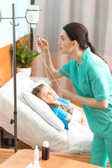 Enfermera colocando medicamento gota a gota en una niña