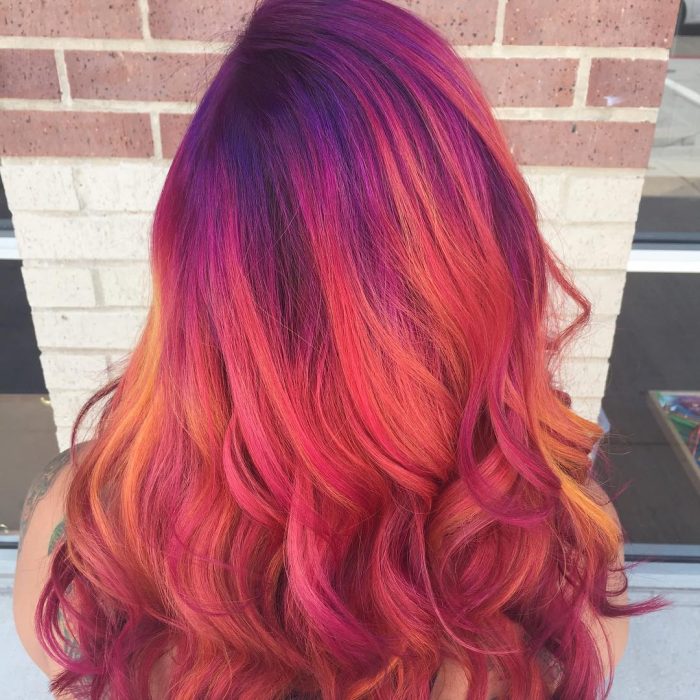 Chica con el cabello teñido con la tendencia sunset hair 