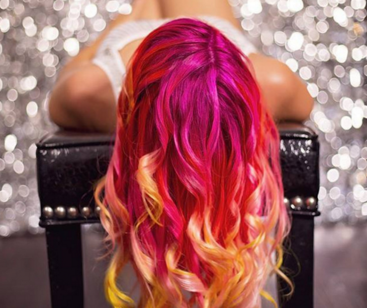 Chica con el cabello teñido de distintos colores, rosa, naranja y amarillo