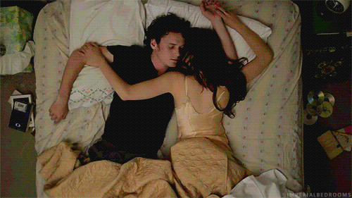 GIF pareja de novios recostados en una cama 