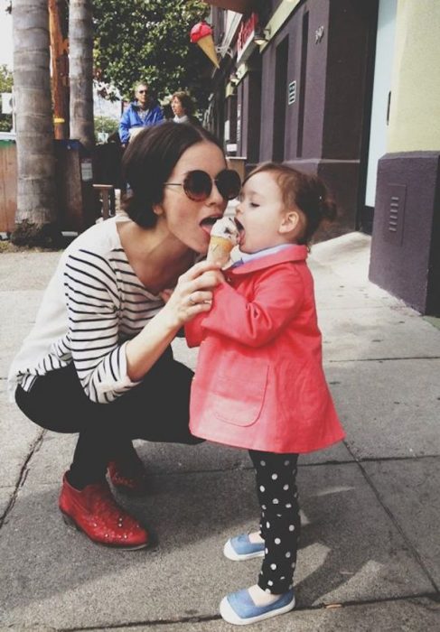 Chica comiendo del helado de una bebé 