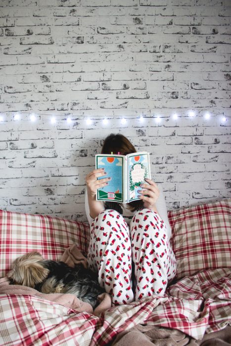 Chica en pijama leyendo un libro 