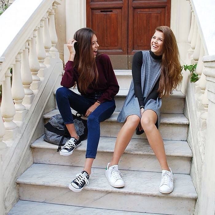 Chicas sentadas en unas escaleras conversando 