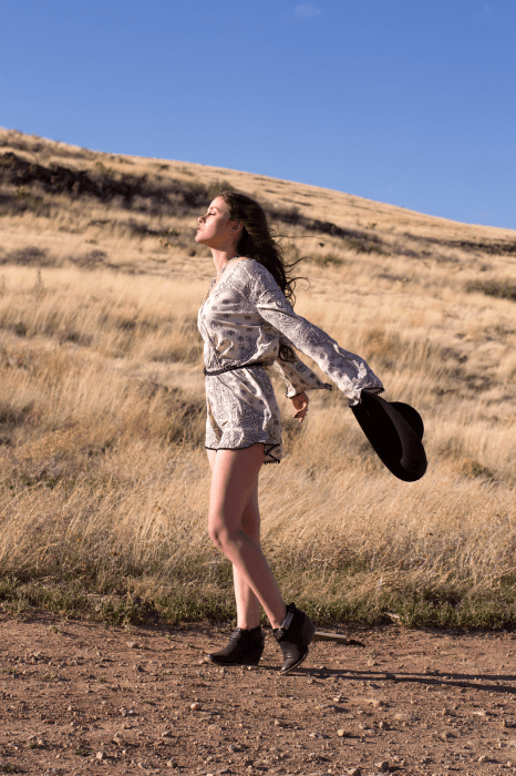 Chica estirando los brazos en medio del desierto 