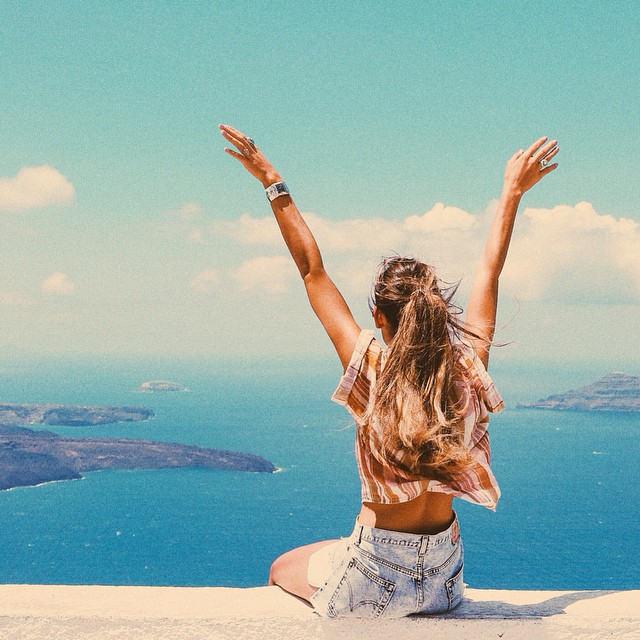 Chica con los brazos abiertos viendo hacia el horizonte 