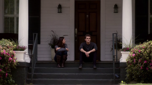 Escena de la serie the vampire diares elena y stefan hablando sentados en las escaleras de una casa 