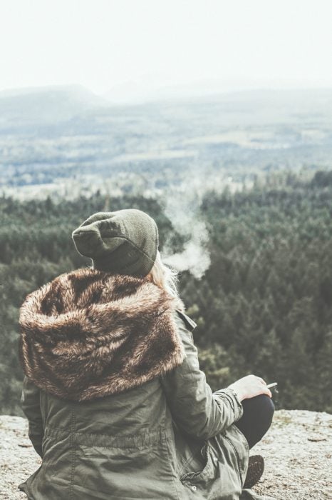 Chica fumando en una montaña 