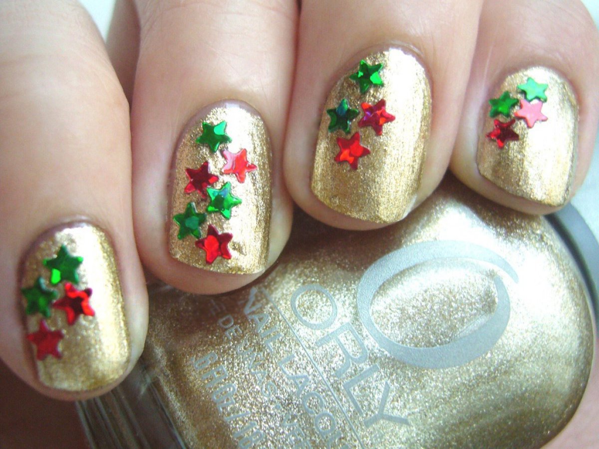 Diseño de uñas navideño, uñas decoradas con esmalte dorado y estrellas.