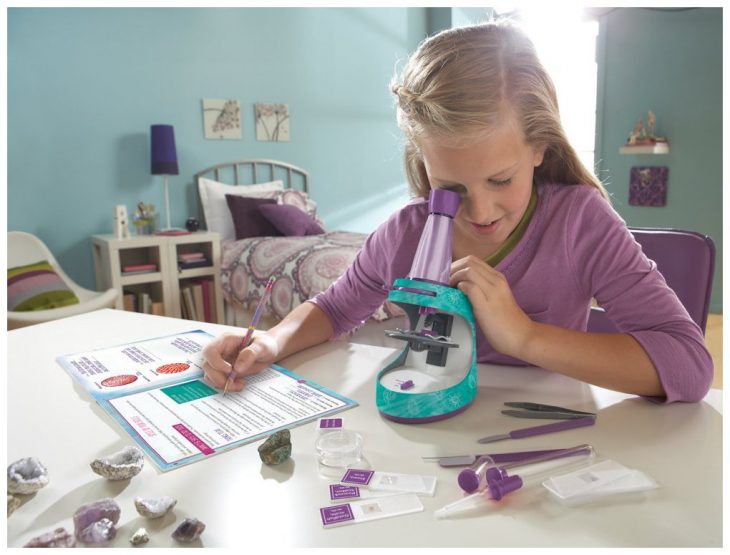 Niña jugando con un microscopio de juguete