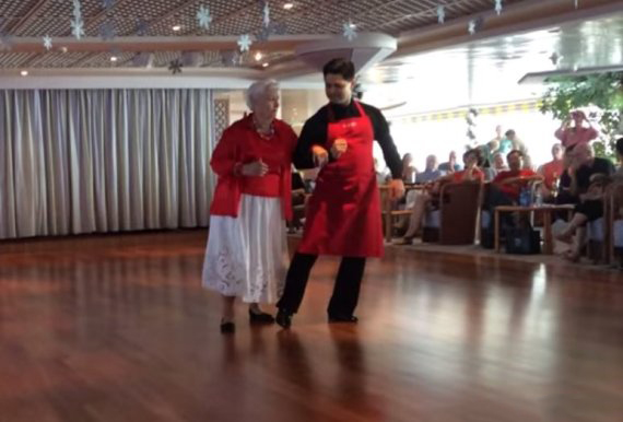 Mujer de 87 años que vive en un crucero bailando con un mesero 