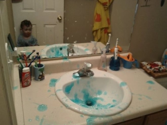 Niño destullendo el baño de su casa con pasta dental 