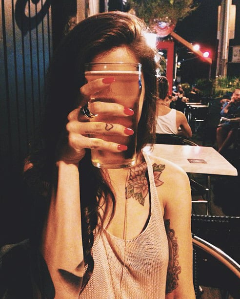 Chica sosteniendo una cerveza en las manos 