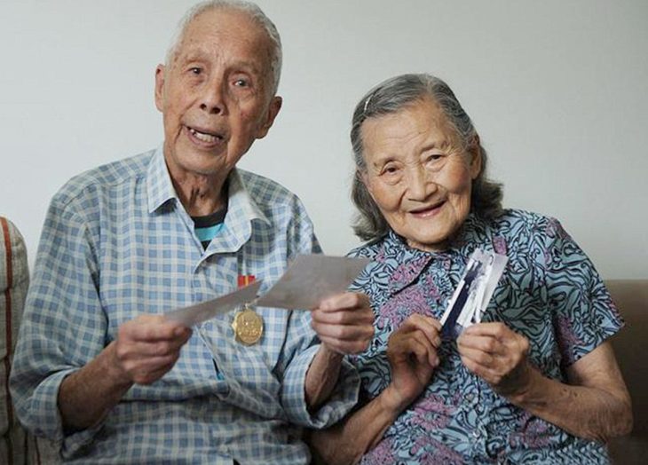 Cao Yuehua y Wang Deyi viendo fotografías