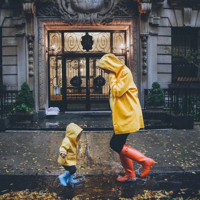 Madre e hija jugando bajo la lluvia 