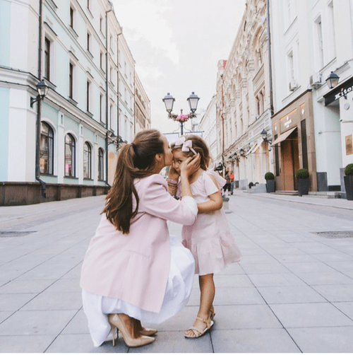 Madre besando a su hija en la frente 