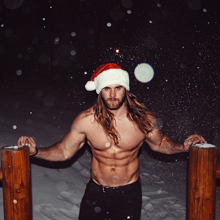 Brock O'Hurn sin camisa y usando un gorro de navidad 