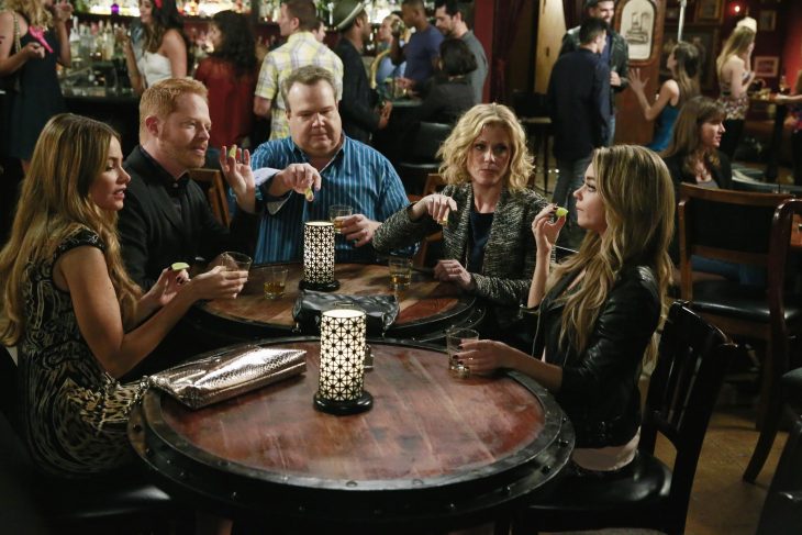 Escena de la serie modern family chica tomando un trago con su familia 