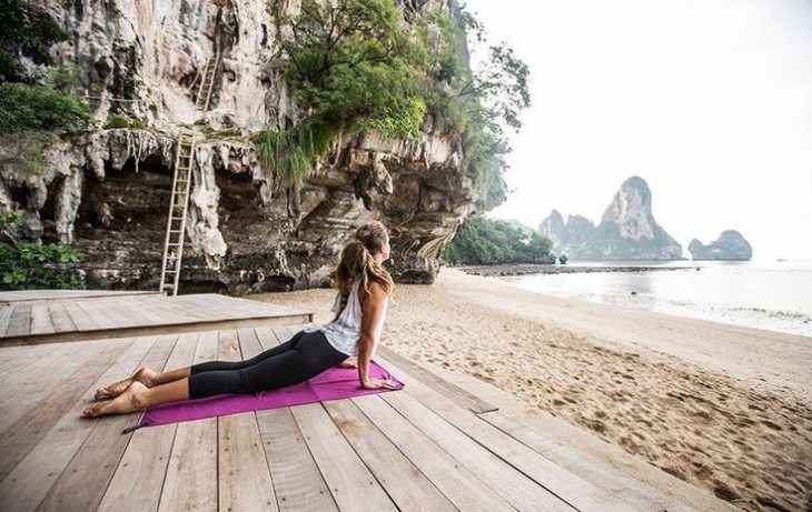 chica haciendo yoga en la playa