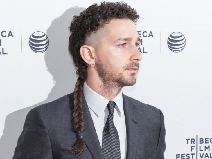 hombre con cabello corto a los lados y trenza larga atrás