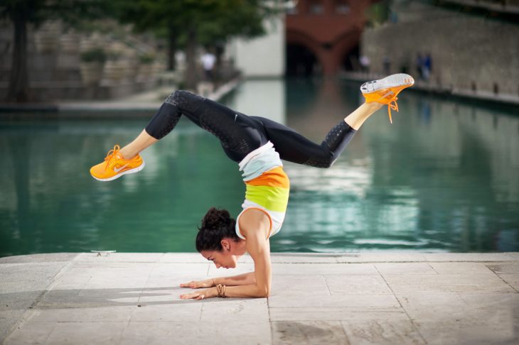 Chica practicando yoga frente a un a alberca