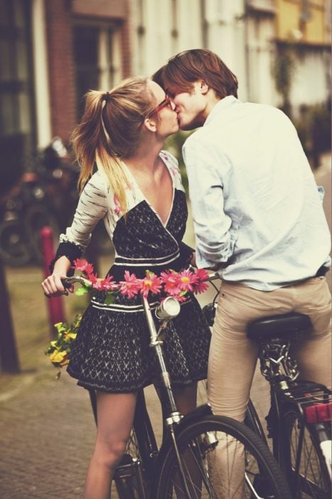 Pareja en bicicleta besándose 