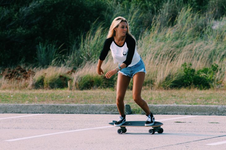 Chica en una patineta haciendo piruetas