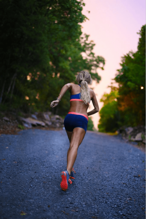 Chica corriendo en medio de un bosque 