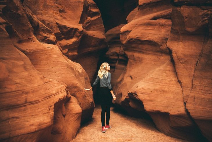 Chica intentando atravesar por enmedio de unas rocas