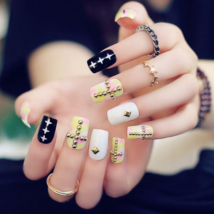 Chica con las uñas en color negro, blanco y amarillo 