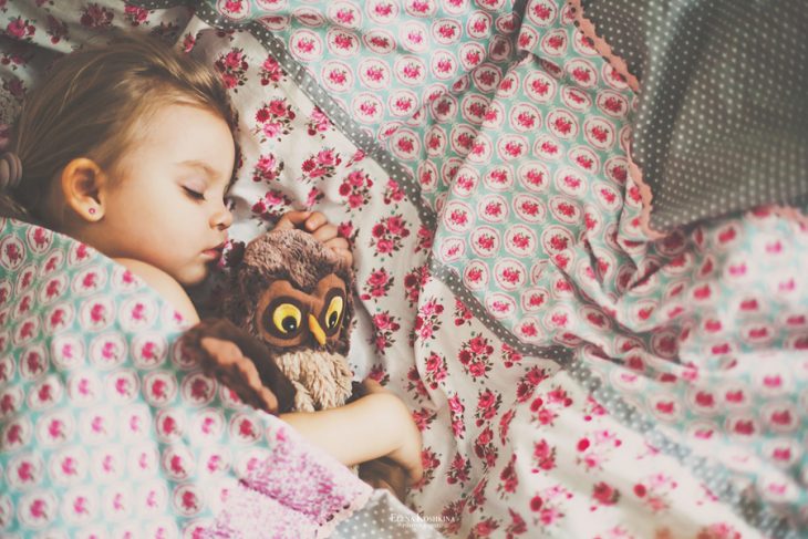 niña dormida abrazando peluche buho