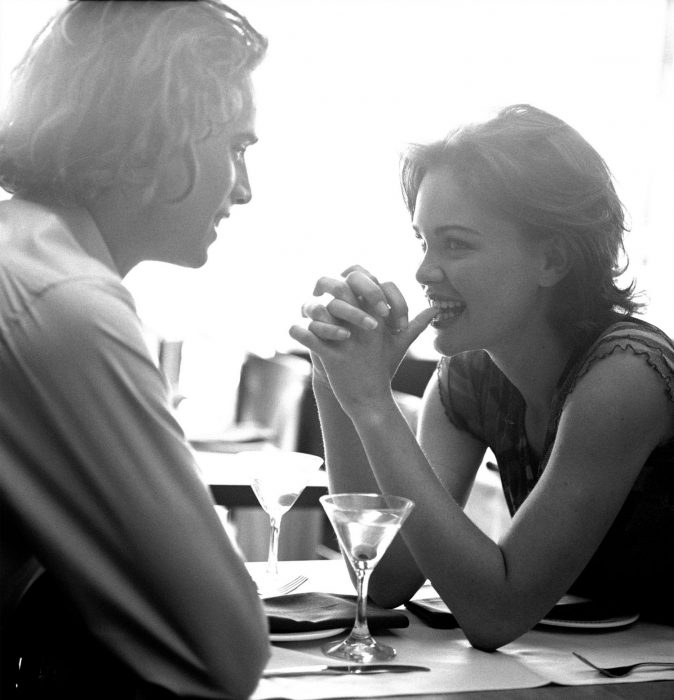 Chica sentada frente a un chico comiendo en un restaurante 