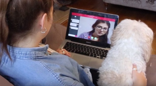 Chica sentada frente a la computadora mientras habla con otra por skype 