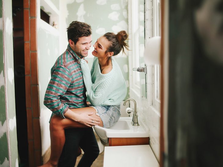 Pareja de novios riendo mientras están en una habitación 