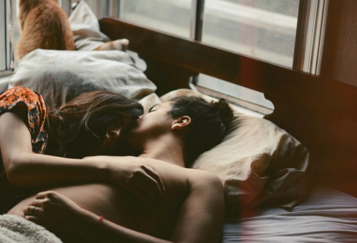 Pareja de novios recostados en una cama 