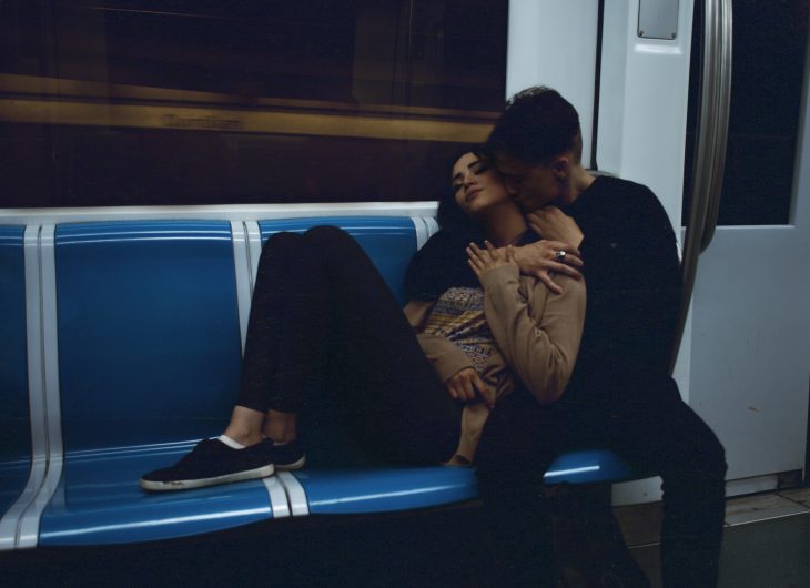 pareja en vagon metro abrazados