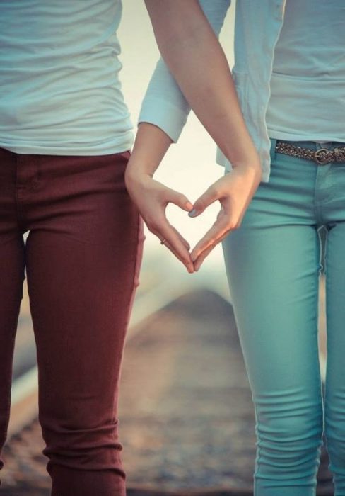 amigas haciendo signo de corazón con la mano