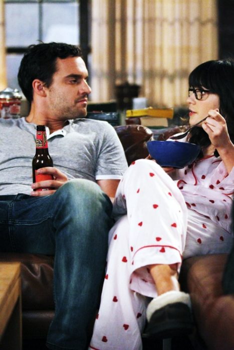 Escena de la serie new girl Nick y jess en el sofá en pijamas