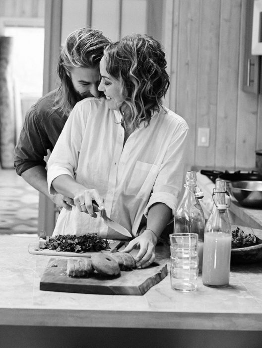 Chica cocinándole a un chico que la abraza