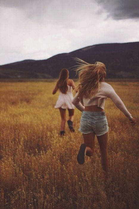 Amigas corriendo en el campo 