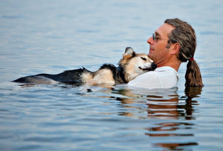 hombre dando terapia de agua helada a su perro