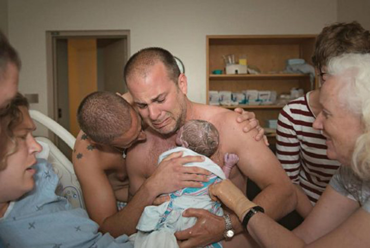 pareja de padres gay abrazan hijo recién nacido