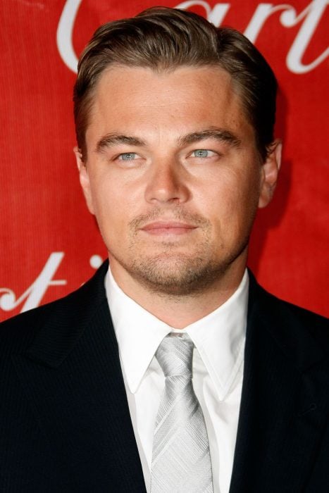 Leonardo DiCaprio usando un traje negro, una camisa blanca y una corbata en color gris 