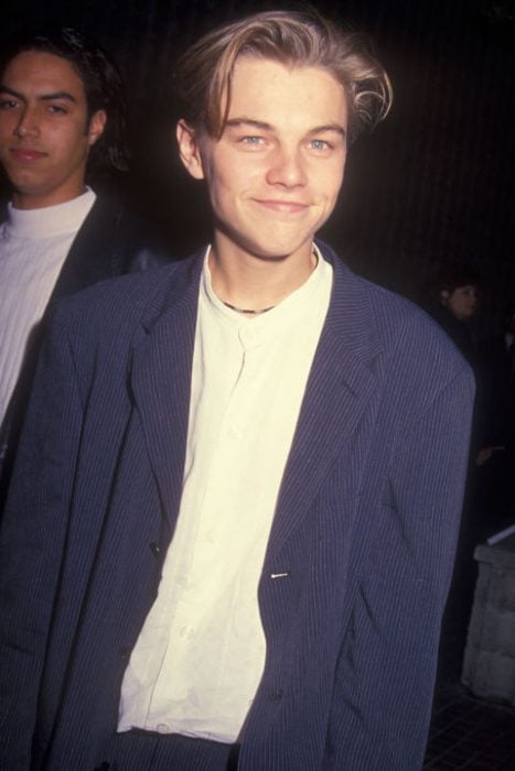 Leonardo DiCaprio usando un trqaje color azul y una camisa amarilla en 1994