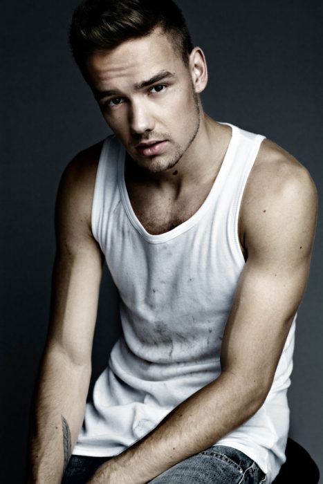 Liam Payne posando para una revista mientras usa una camisa blanca y tiene algunas manchas de aceite 