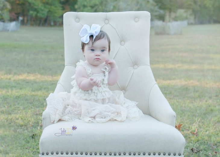 Fotógrafa Julie Wilson capturando la belleza de un niña con síndrome de down sentada en una silla 