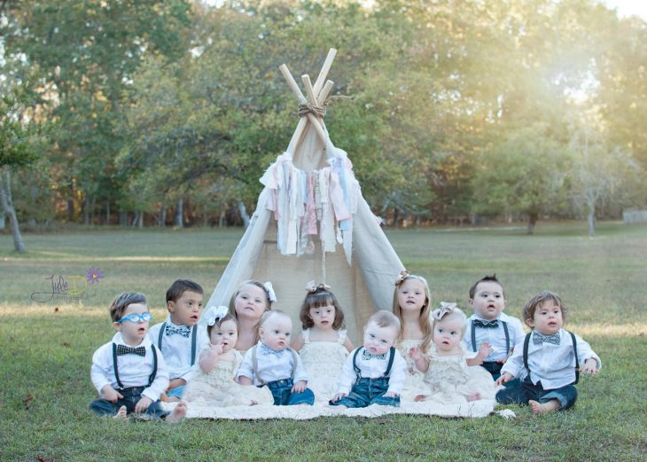 Fotógrafa Julie Wilson capturando la belleza de unos niños con síndrome de down sentados en el pasto 