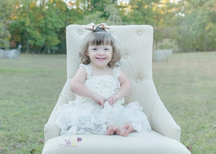 Fotógrafa Julie Wilson capturando la belleza de un niña con síndrome de down sentada en una silla 