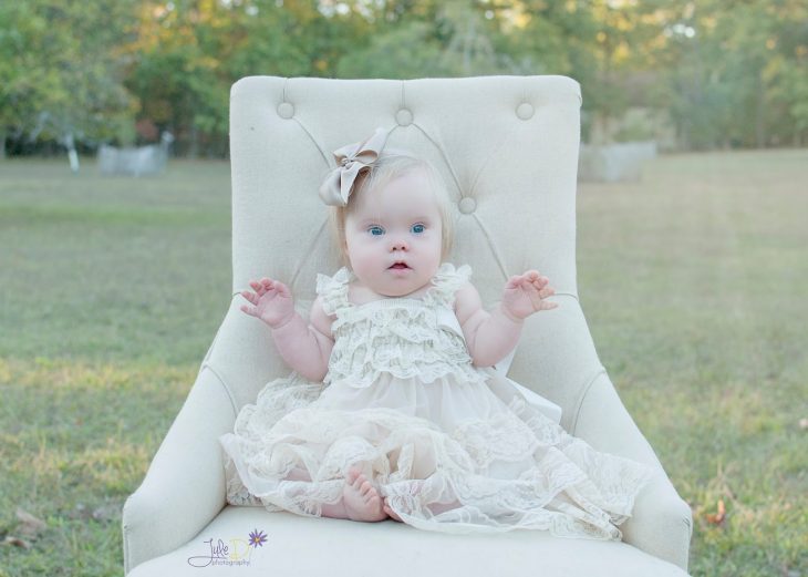 Fotógrafa Julie Wilson capturando la belleza de un niña con síndrome de down sentada en una silla 